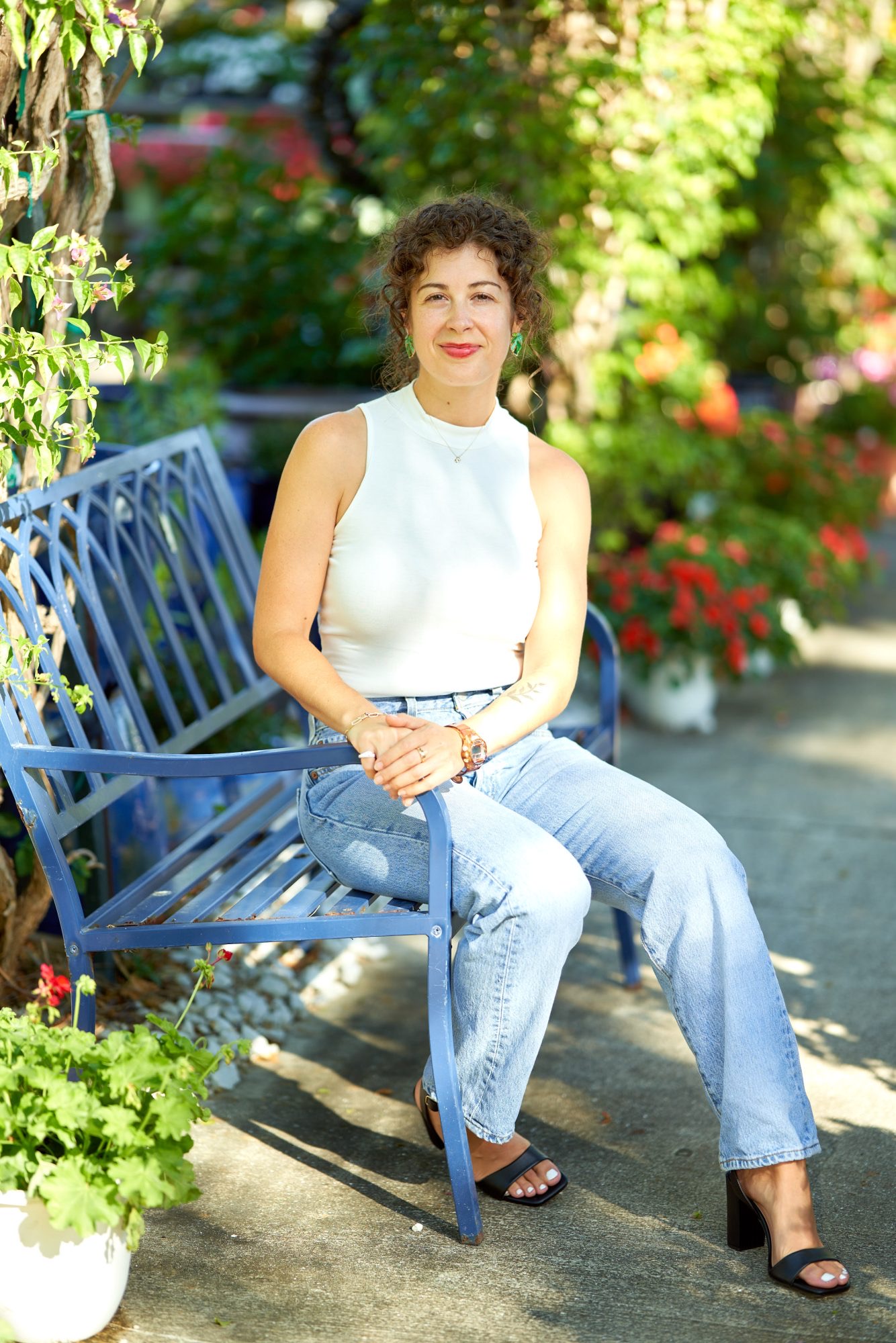 Caitlin seated on a blue garden bench