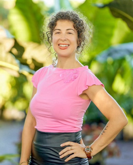 Caitlin Cherner smiling in a sunlit garden